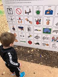 Young boy standing in front of the playground board