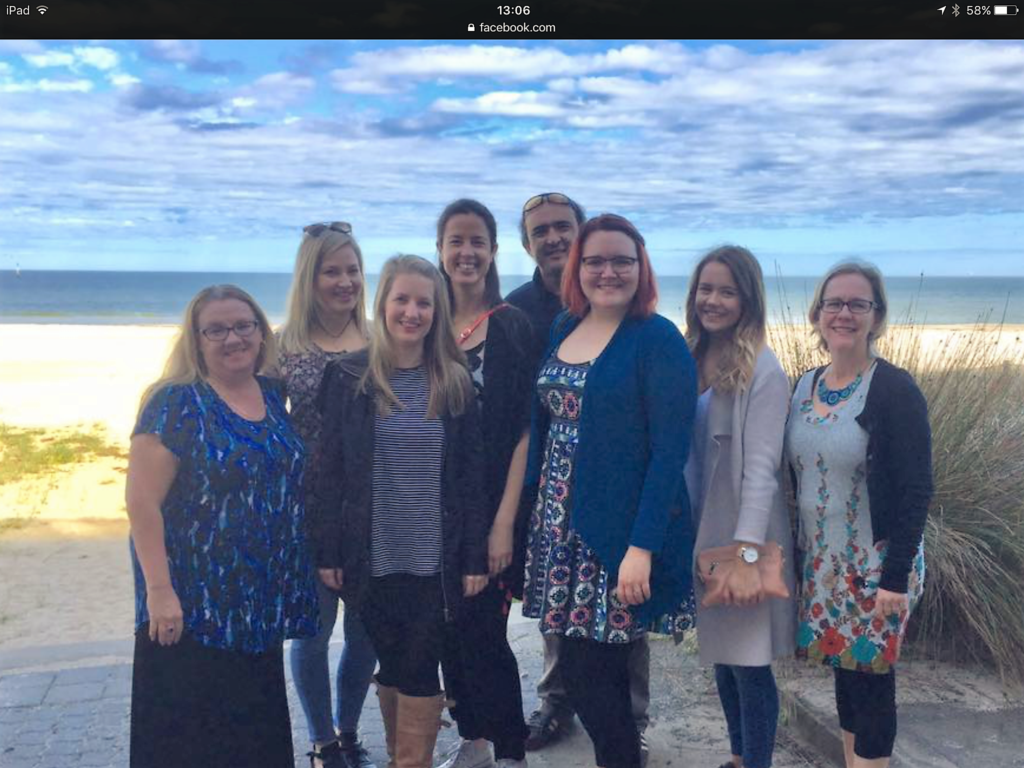 Photo of 8 Two Way Street staff members standing in front of the beach